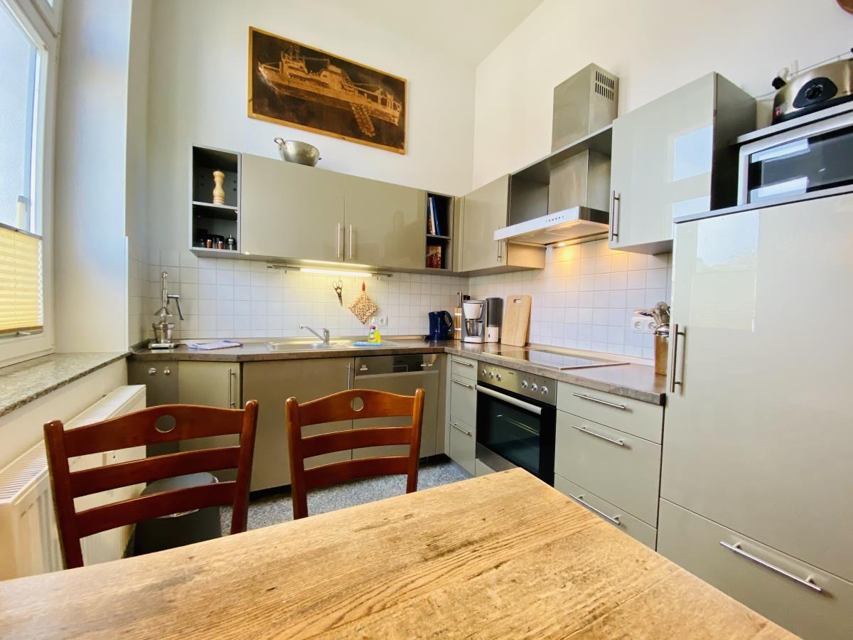 Küche mit Essbereich, Holztisch, zwei Stühlen und moderner Ausstattung.