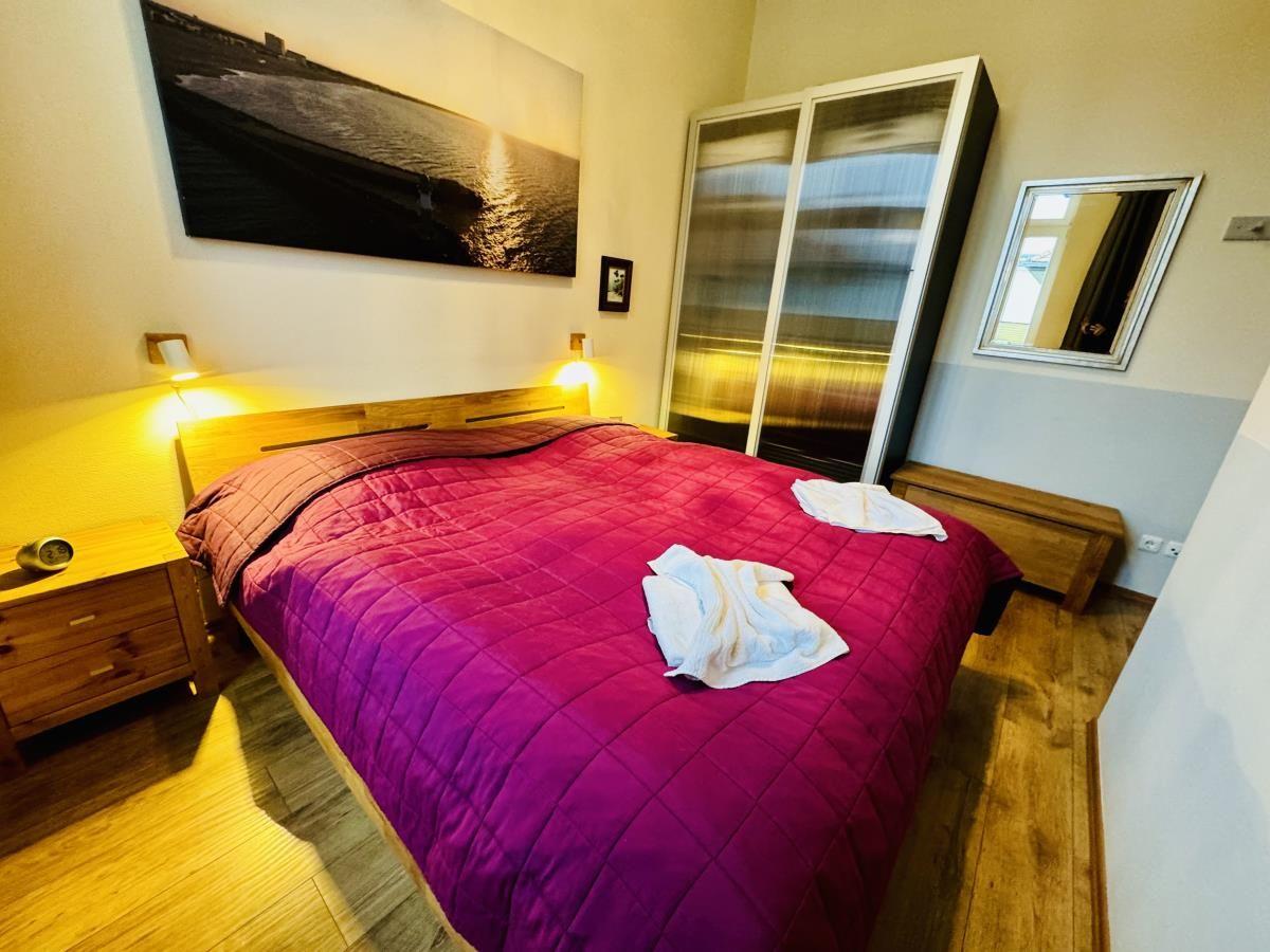 Schlafzimmer mit Doppelbett, Holzmöbeln und Wandbild.