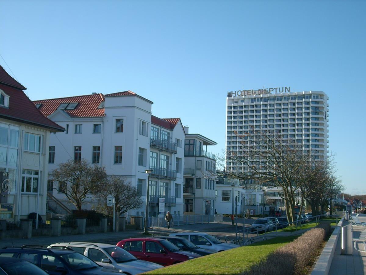 Hotel Neptun und umliegende Gebäude mit Parkplatz und Bäumen.