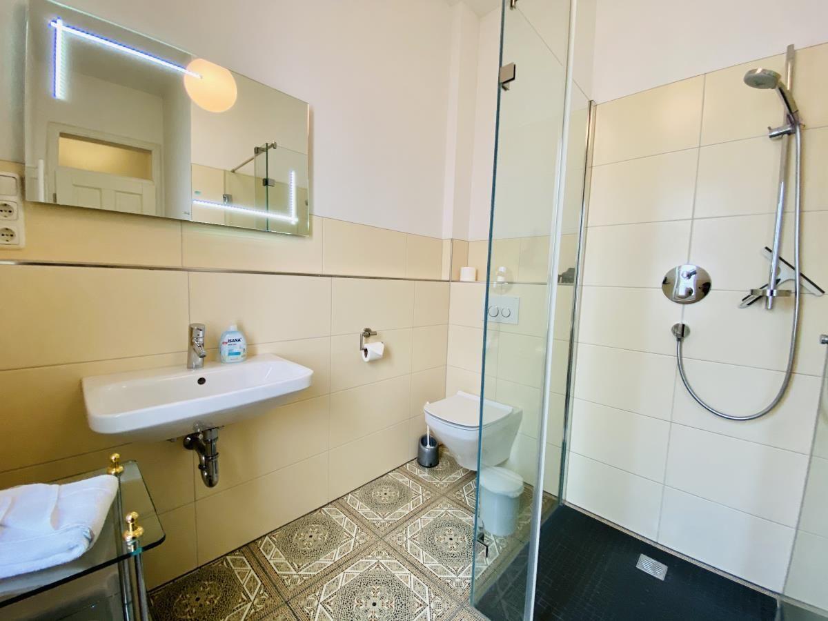 Badezimmer mit Dusche, Waschbecken und Toilette.