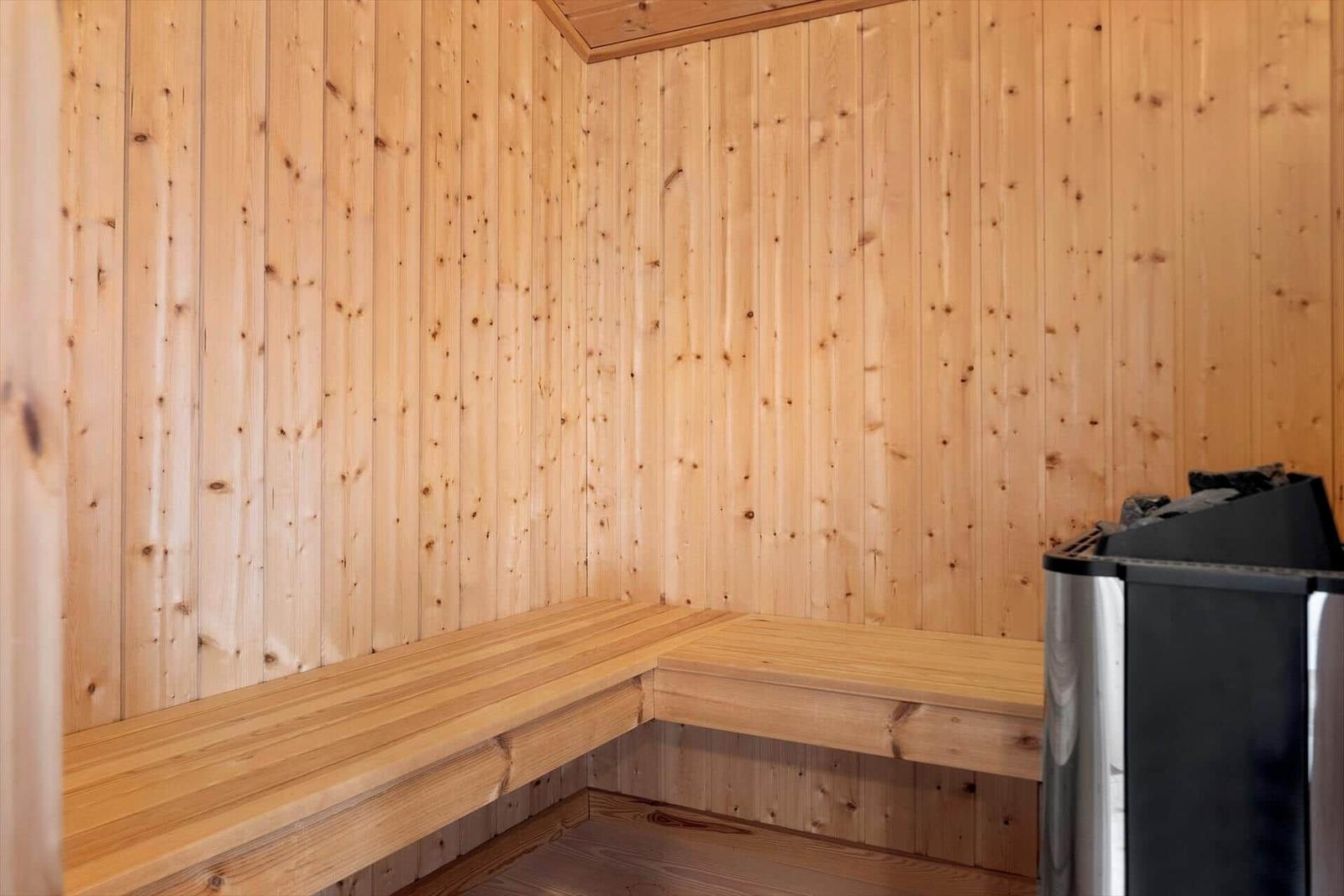 Sauna mit Holzwandverkleidung und Sitzbänken.