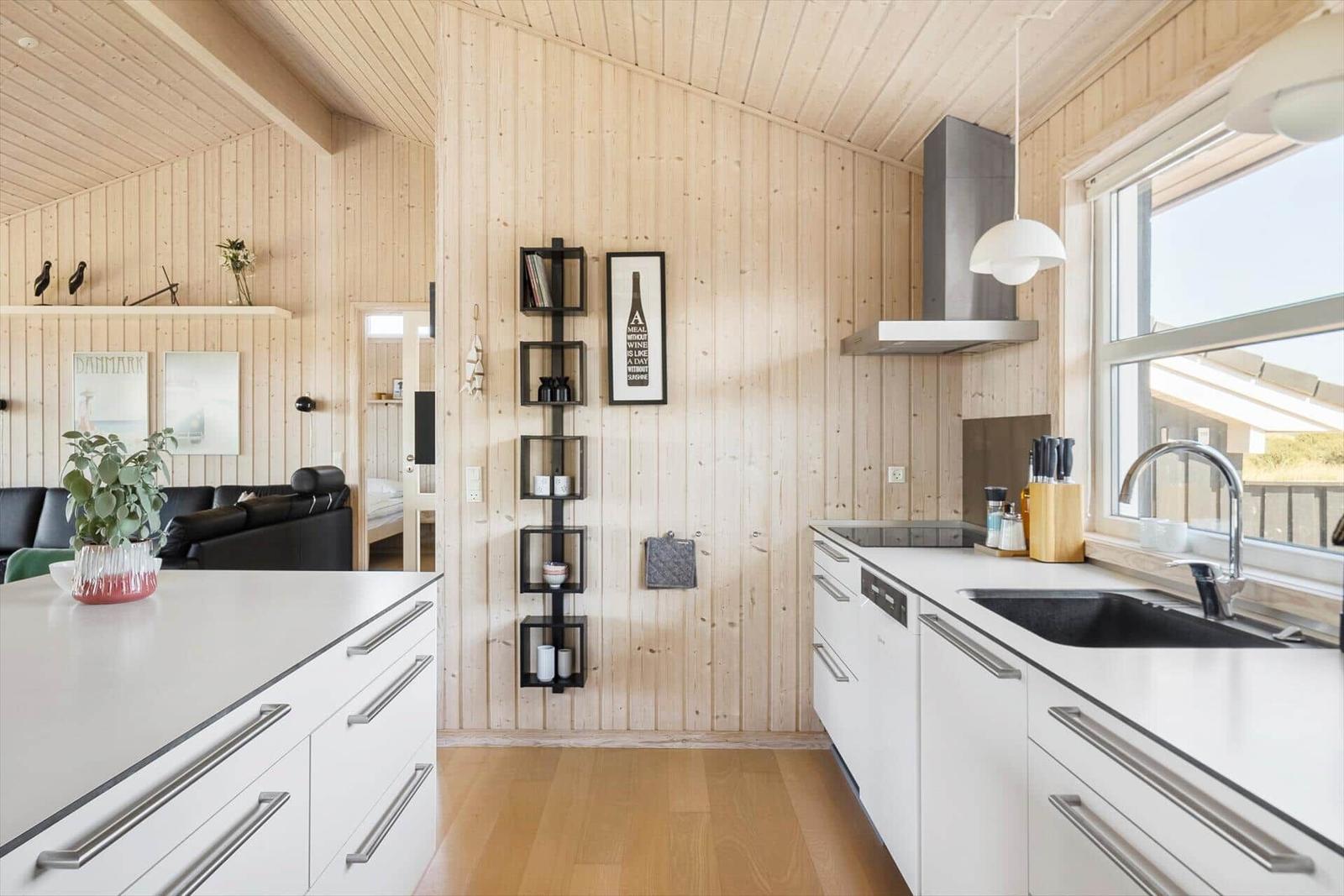 Küche mit Holzwand, Arbeitsfläche und Fenster