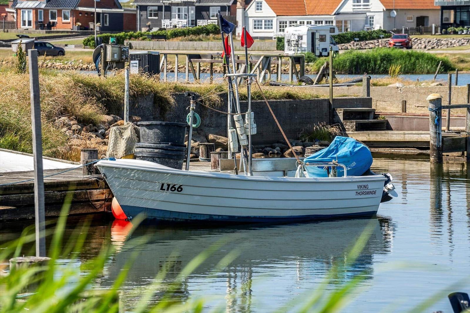 Ein weißes Boot mit dem Namen Viking Thorsminde liegt an einem Steg im Wasser.
