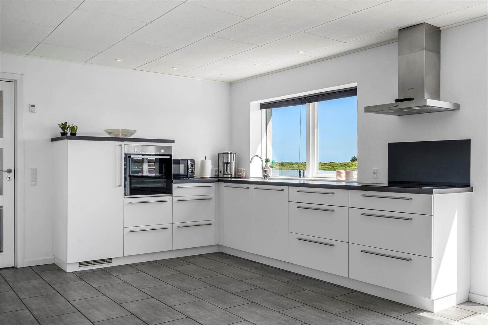 Moderne Küche mit Blick auf Wasser und Grünfläche.