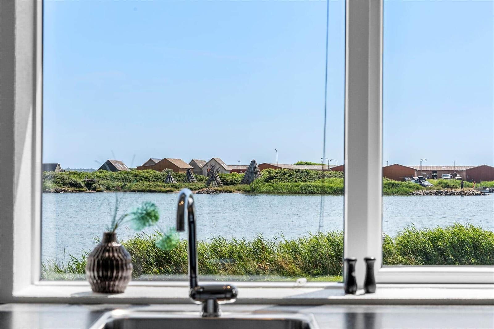 Küchenfenster mit Blick auf Wasser und gegenüberliegende Gebäude.