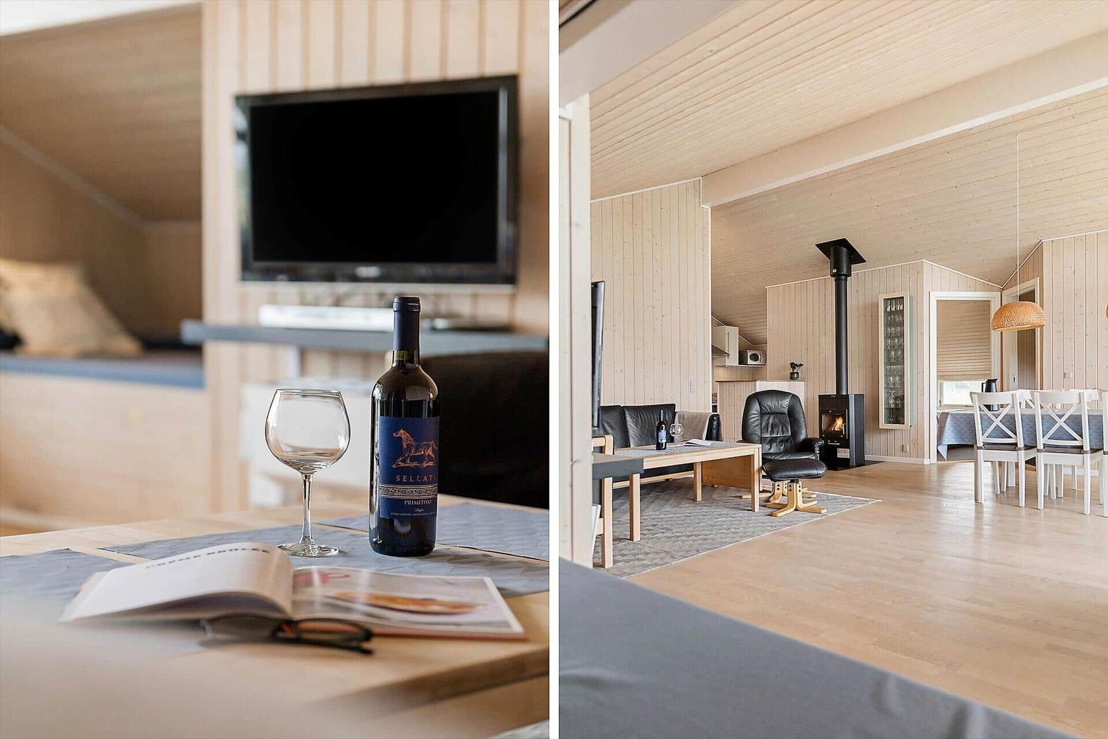 Wohnbereich mit Kamin, Essbereich und TV. Flur mit Weinflasche und Glas.