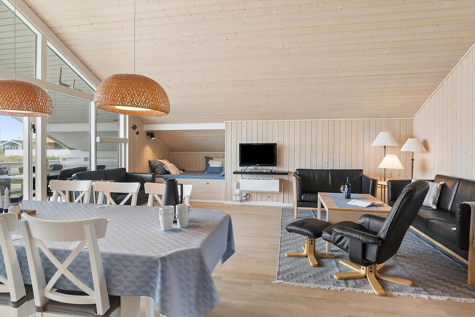 Wohn- und Essbereich mit Sofa, Esstisch und Fernseher.