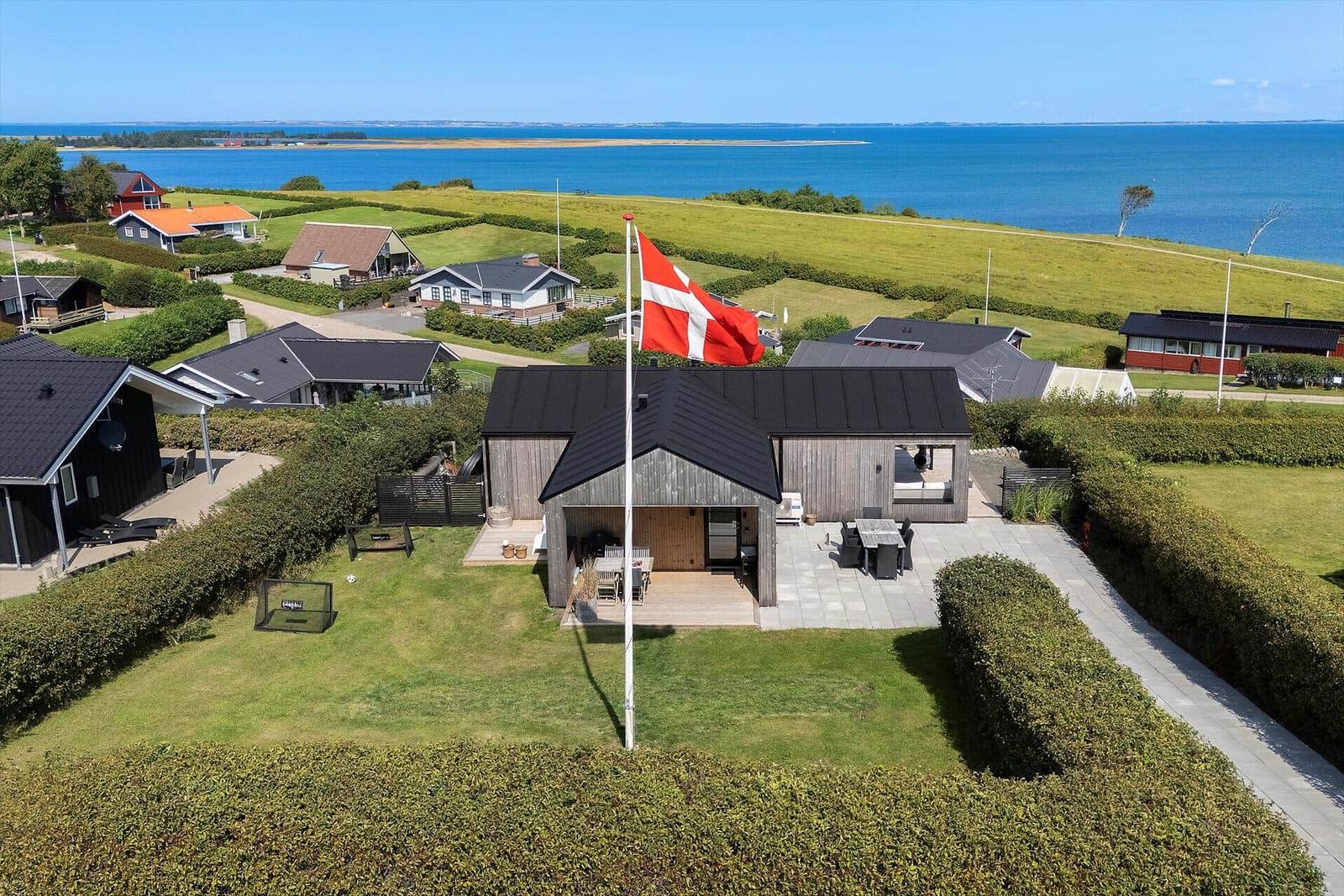 Haus mit Flagge, Terrasse und Blick auf Meer und Grünflächen