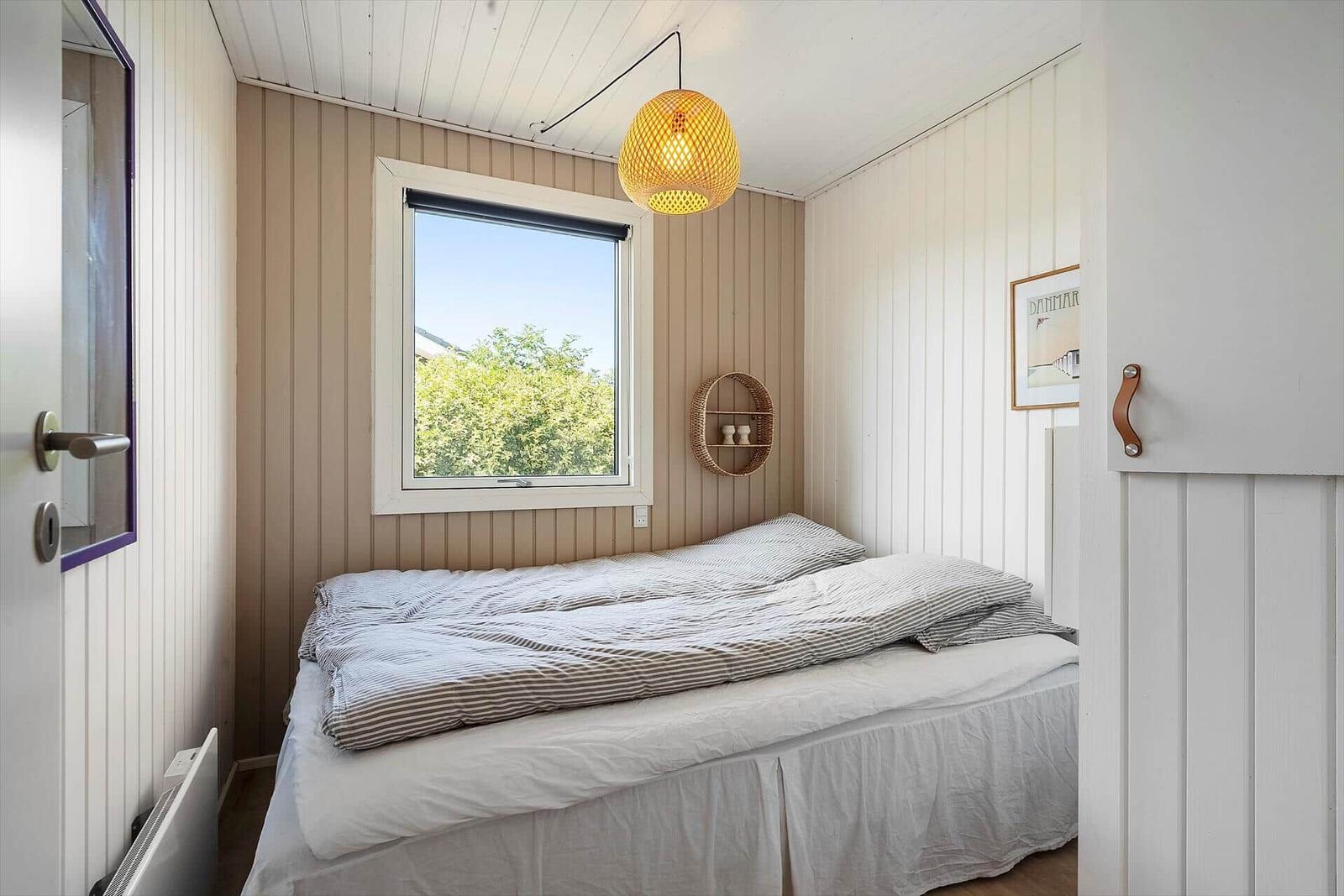 Schlafzimmer mit Bett, Fenster und Deckenlampe