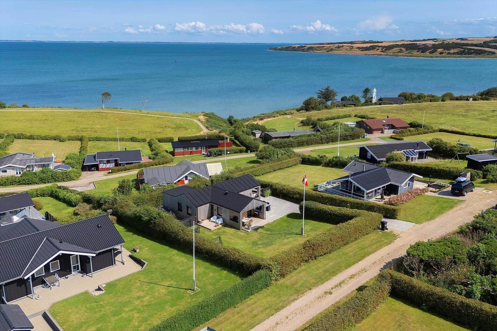 Meerblick auf Ferienhäuser mit Grünflächen und gepflegten Gärten.