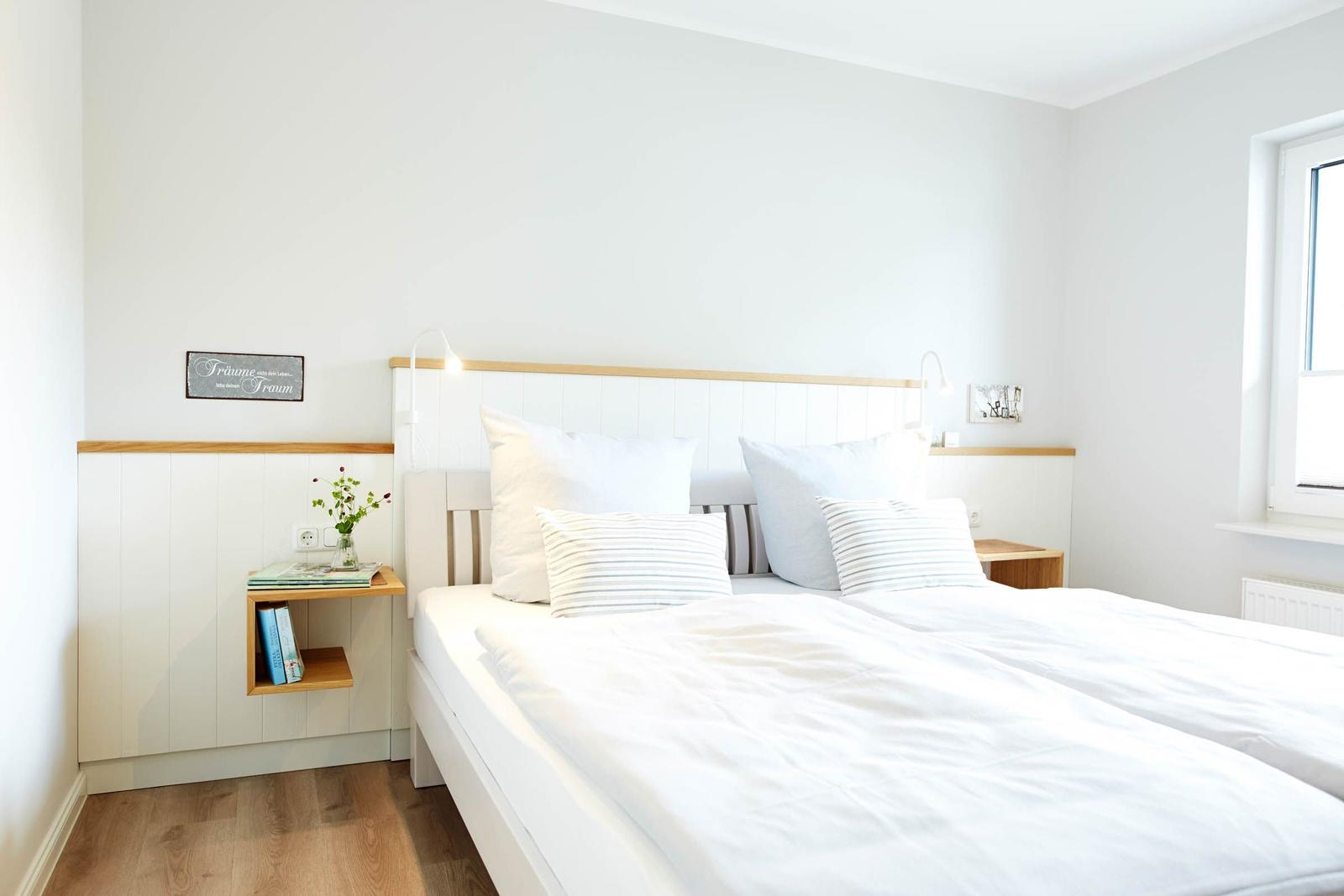 Schlafzimmer mit Bett, Nachttisch und Fenster