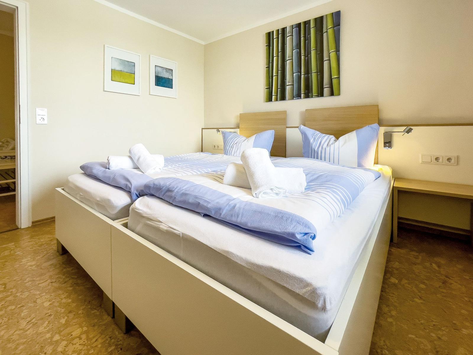 Doppelbett mit blau-weißen Bettwäsche und dekorativen Kissen.