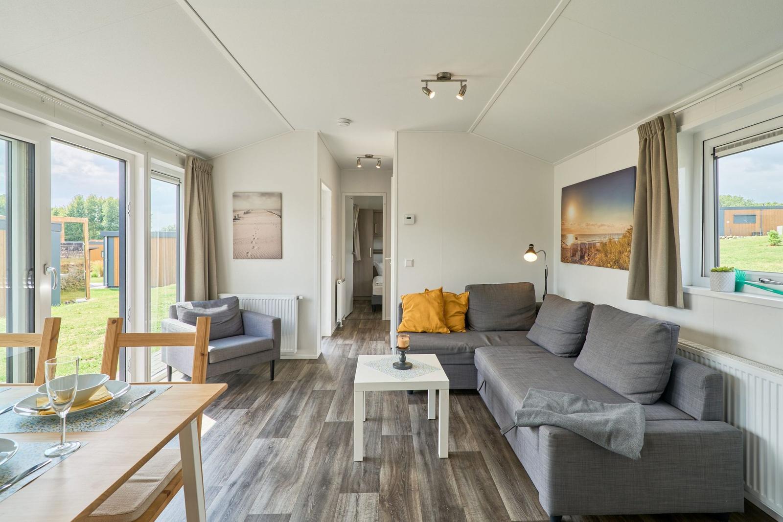 Wohnbereich mit Sofa, Esstisch und Blick auf Garten