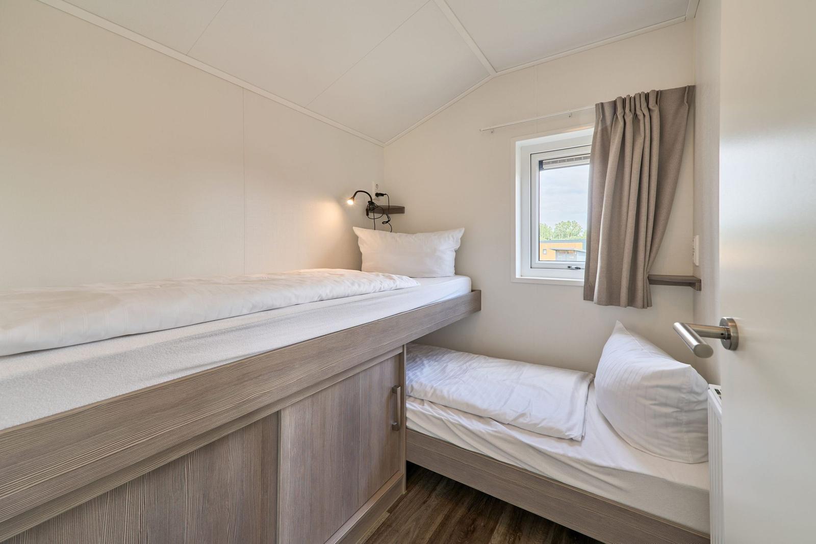 Zimmer mit zwei Betten, Fenster und Nachttisch