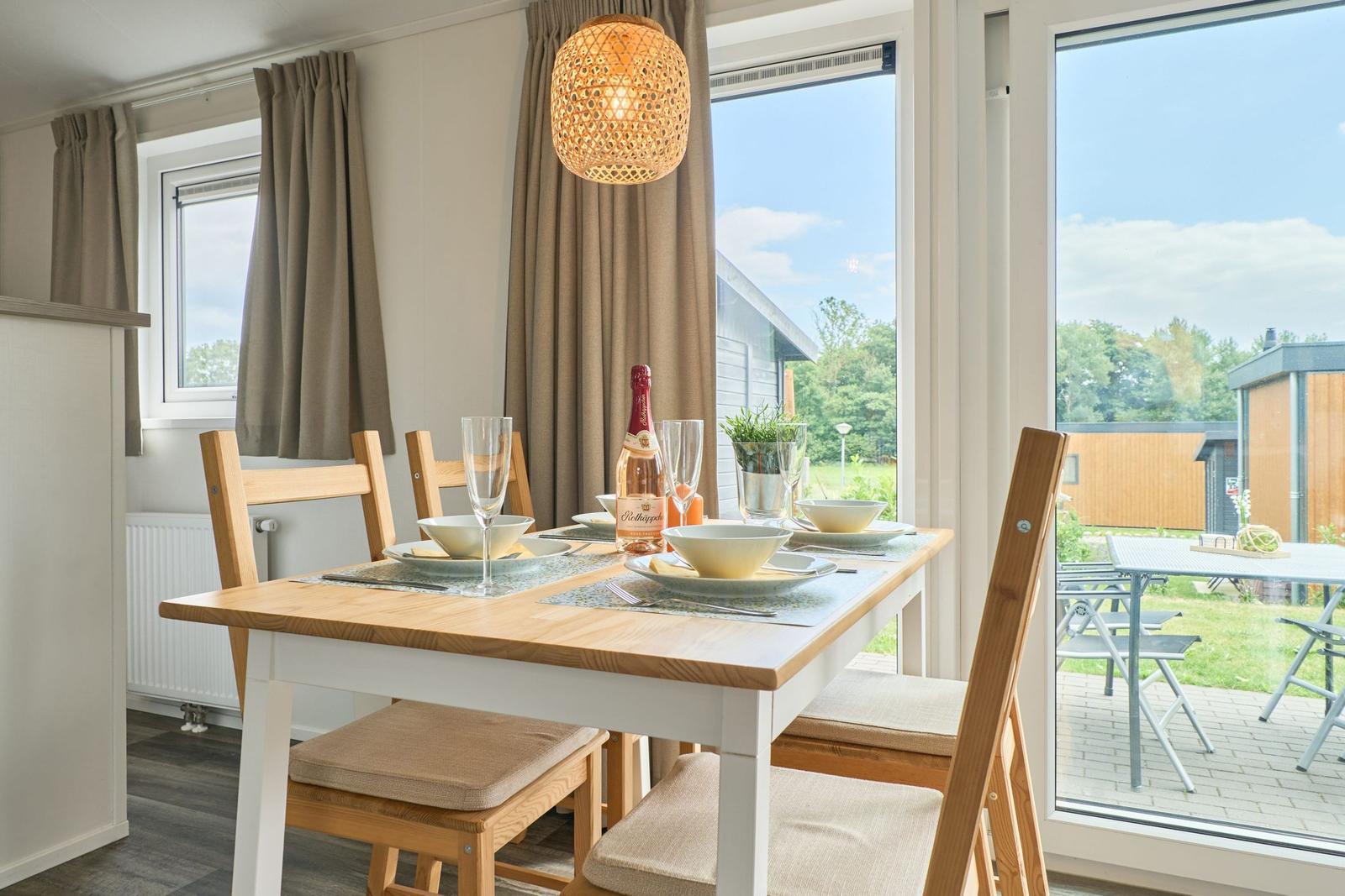 Essbereich mit Tisch, Stühlen und Blick auf Terrasse.