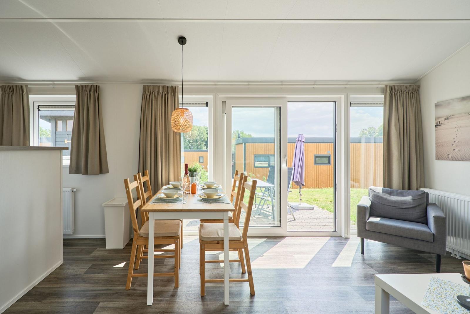 Essbereich mit Tisch und Stühlen, Sitzgelegenheit und Terrassentür.