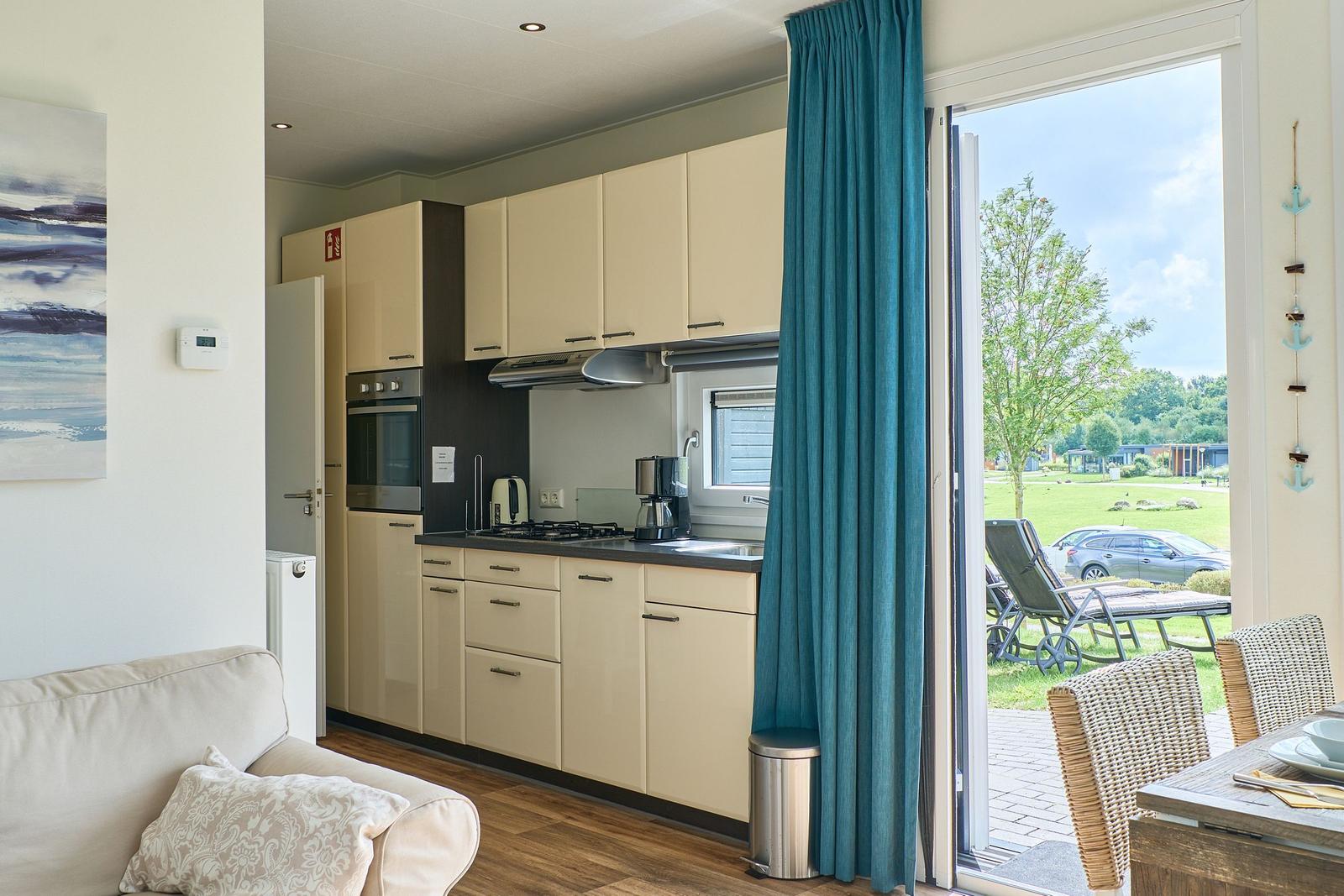 Küche mit Essbereich und Terrasse mit Blick auf Grünflächen.