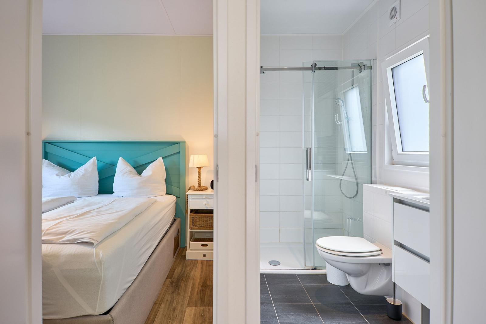 Schlafzimmer mit Bett und Bad mit Dusche und Toilette