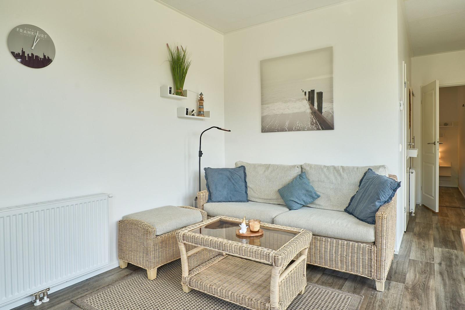 Wohnzimmer mit Sofa, Couchtisch und Wanduhr Frankfurt.