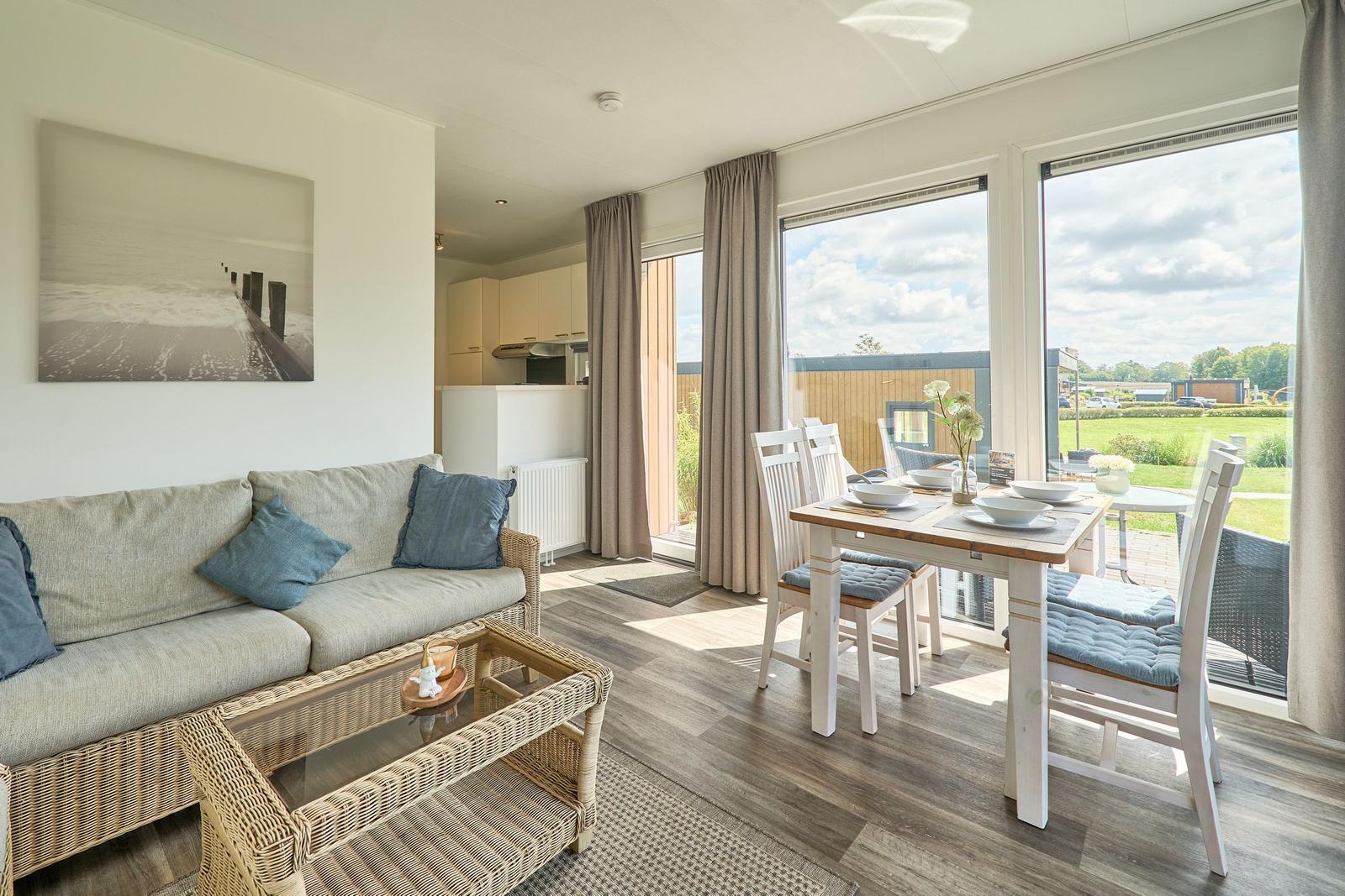 Wohn- und Essbereich mit Blick auf die Terrasse und Grünfläche.