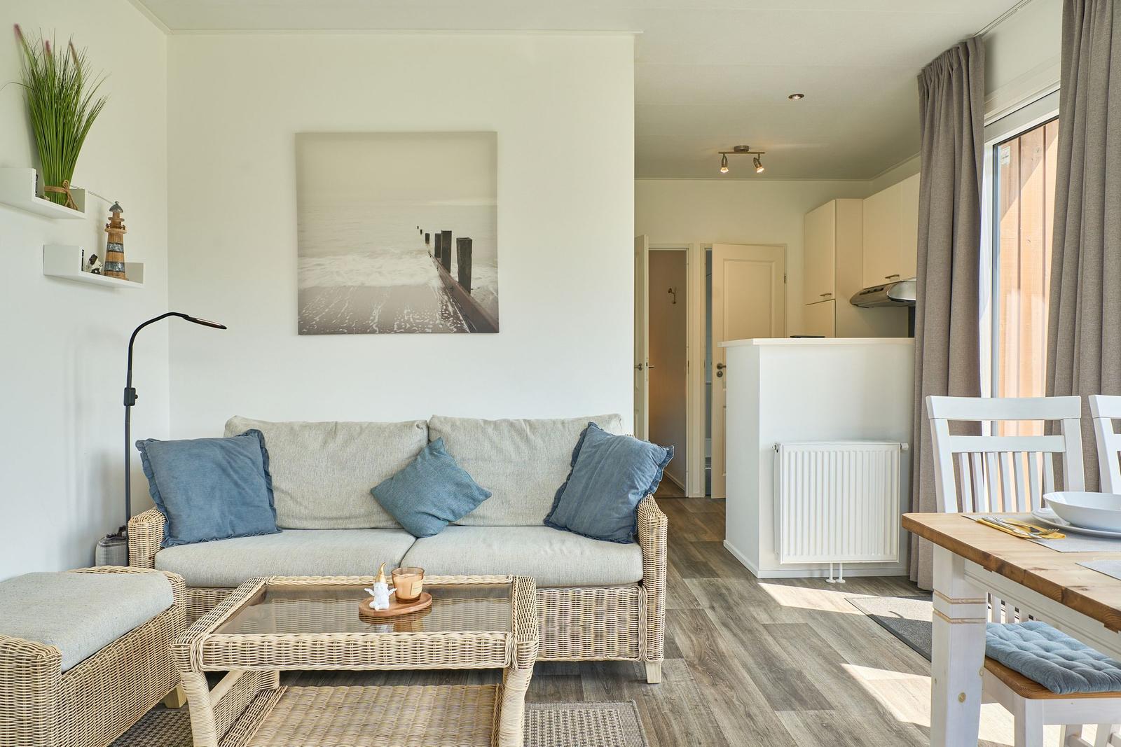 Wohn- und Essbereich mit Sofa, Tisch und Küchenbereich.