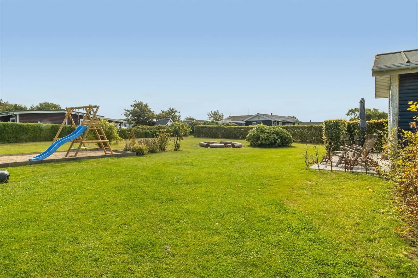 Large garden with playground, fire pit, and seating area.