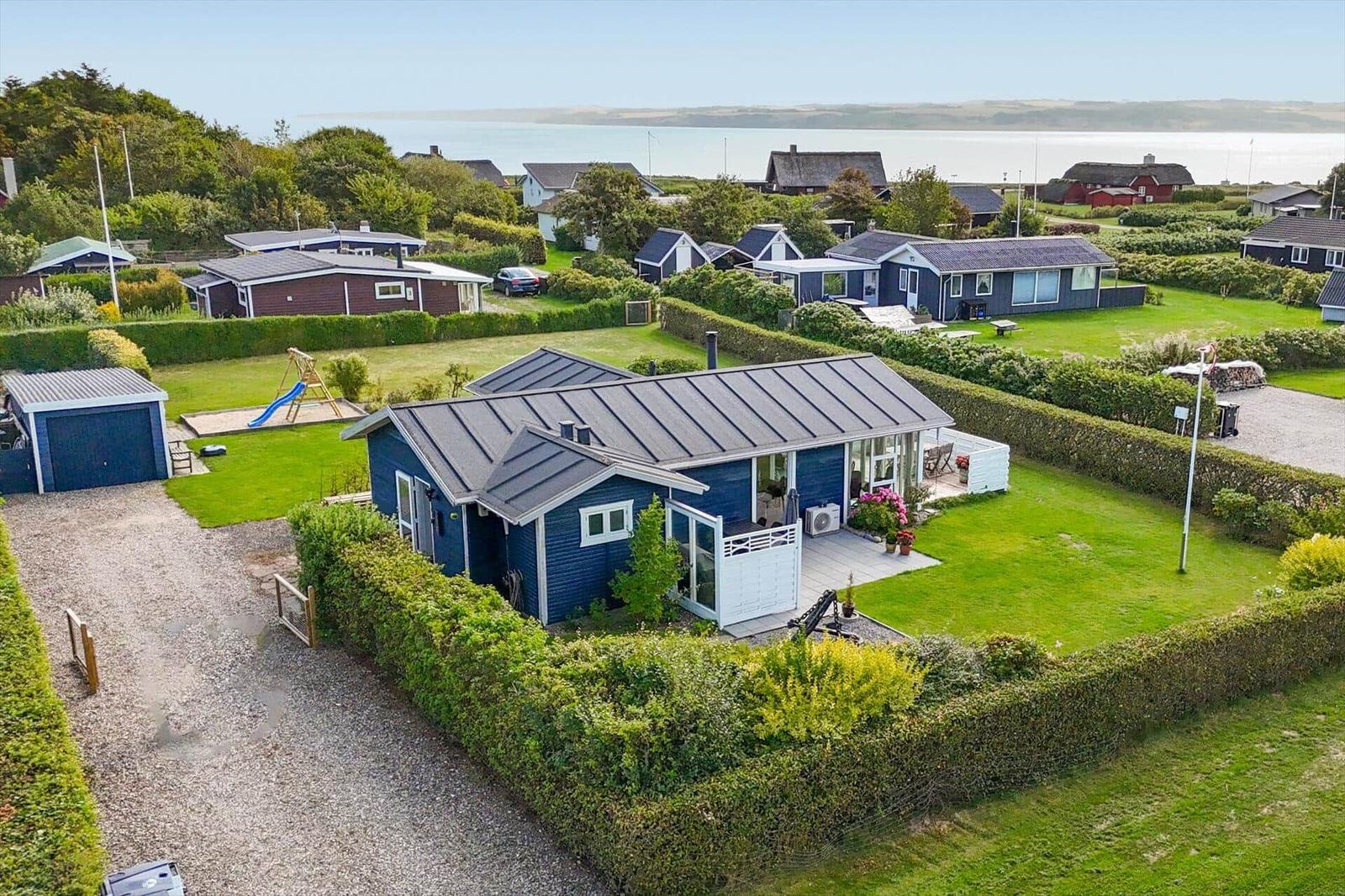 Blue holiday home with garden and sea view.