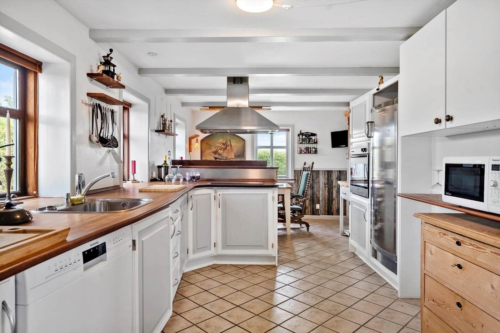 Kitchen with wooden countertops, white cabinets, and stainless steel appliances.