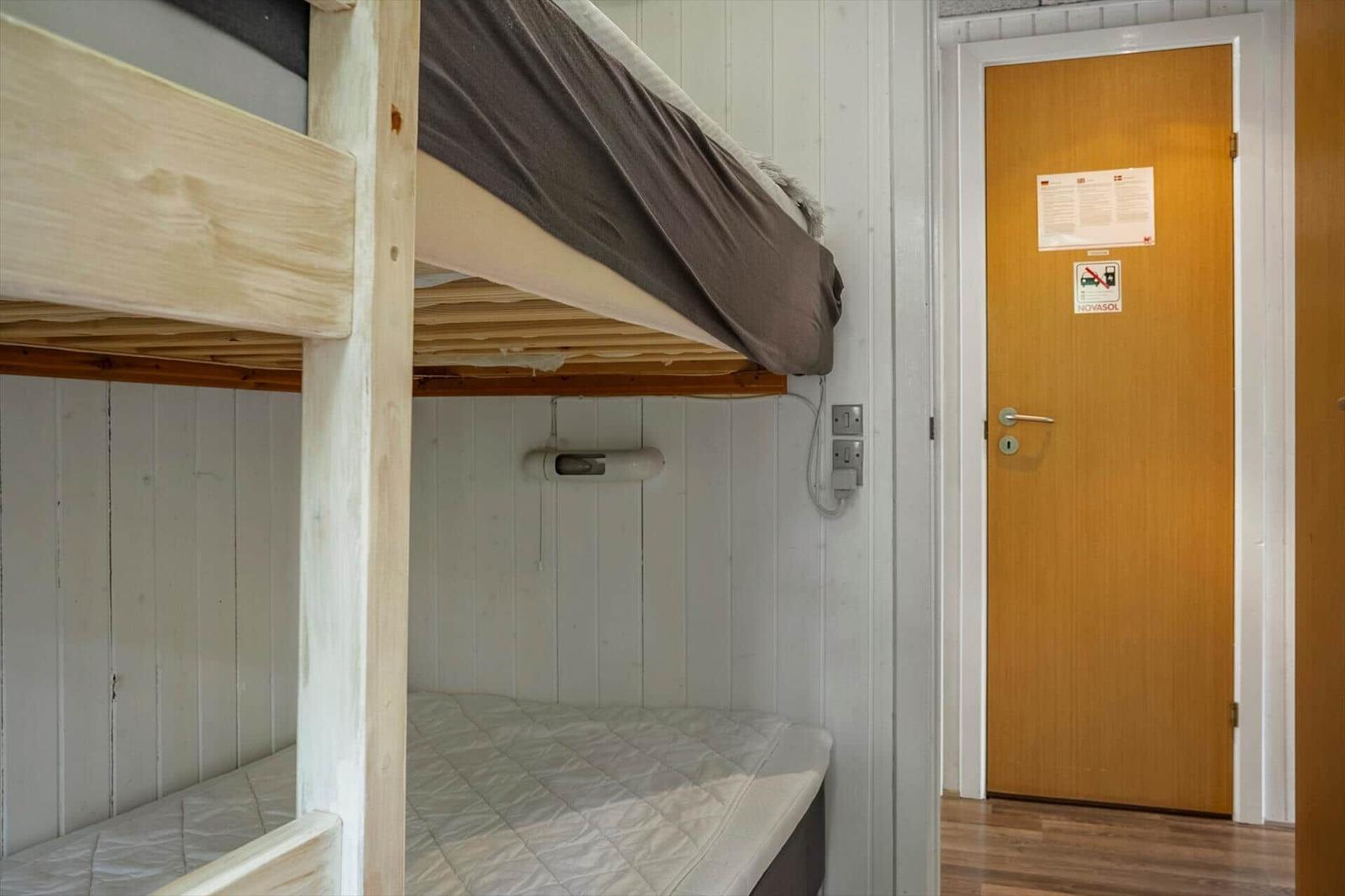 Room with bunk bed and door with stickers.