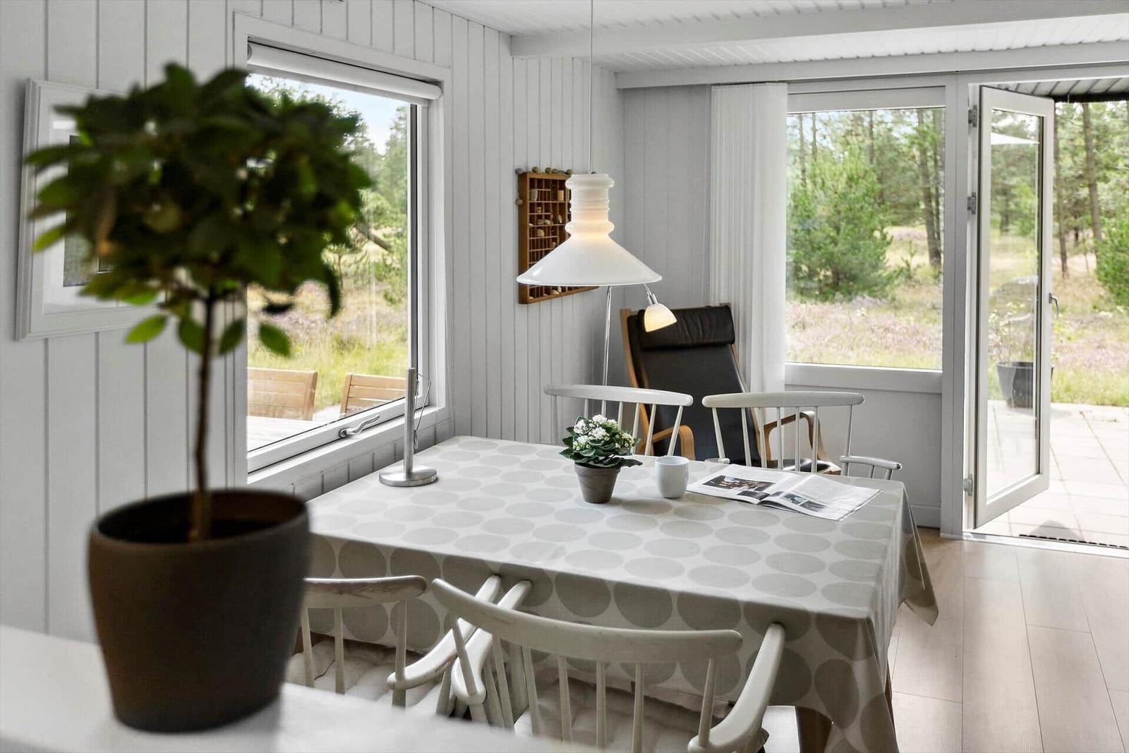 Esszimmer mit Tisch, Stühlen und Blick auf den Garten.