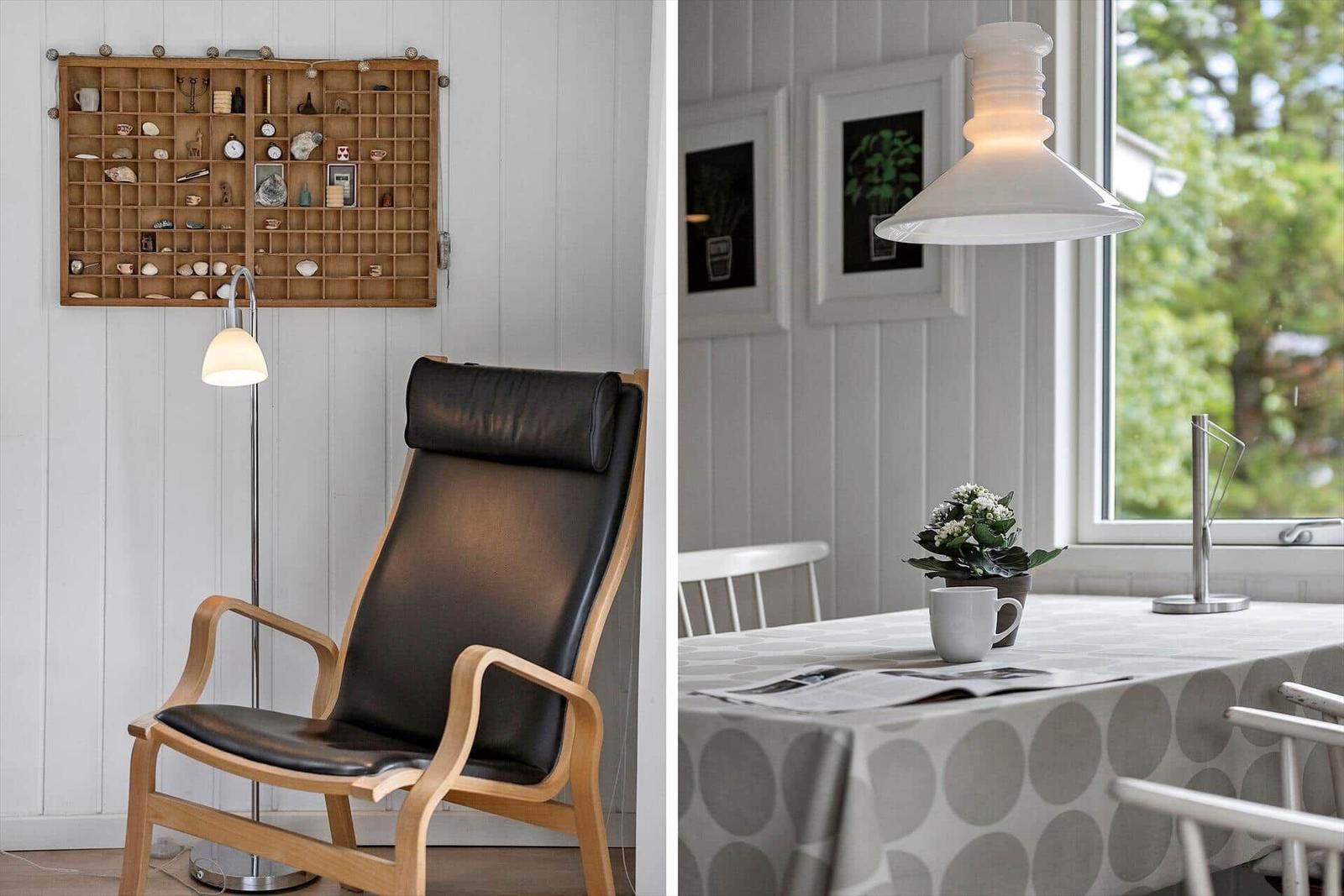 Schwarzer Ledersessel mit Holzrahmen und Wandregal mit Sammlerobjekten.