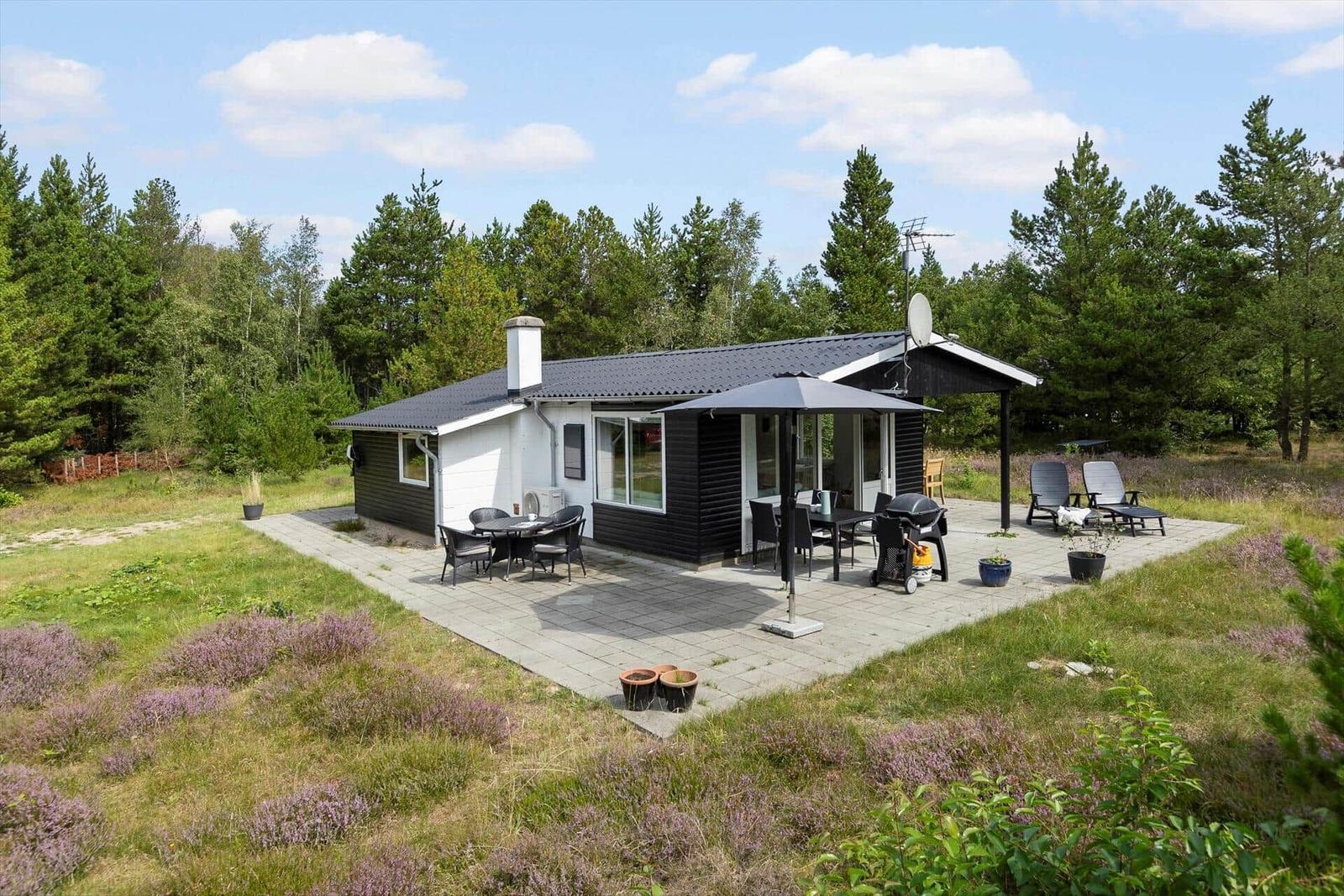 Moderne Ferienhaus mit Terrasse, Grill und Garten im Wald.
