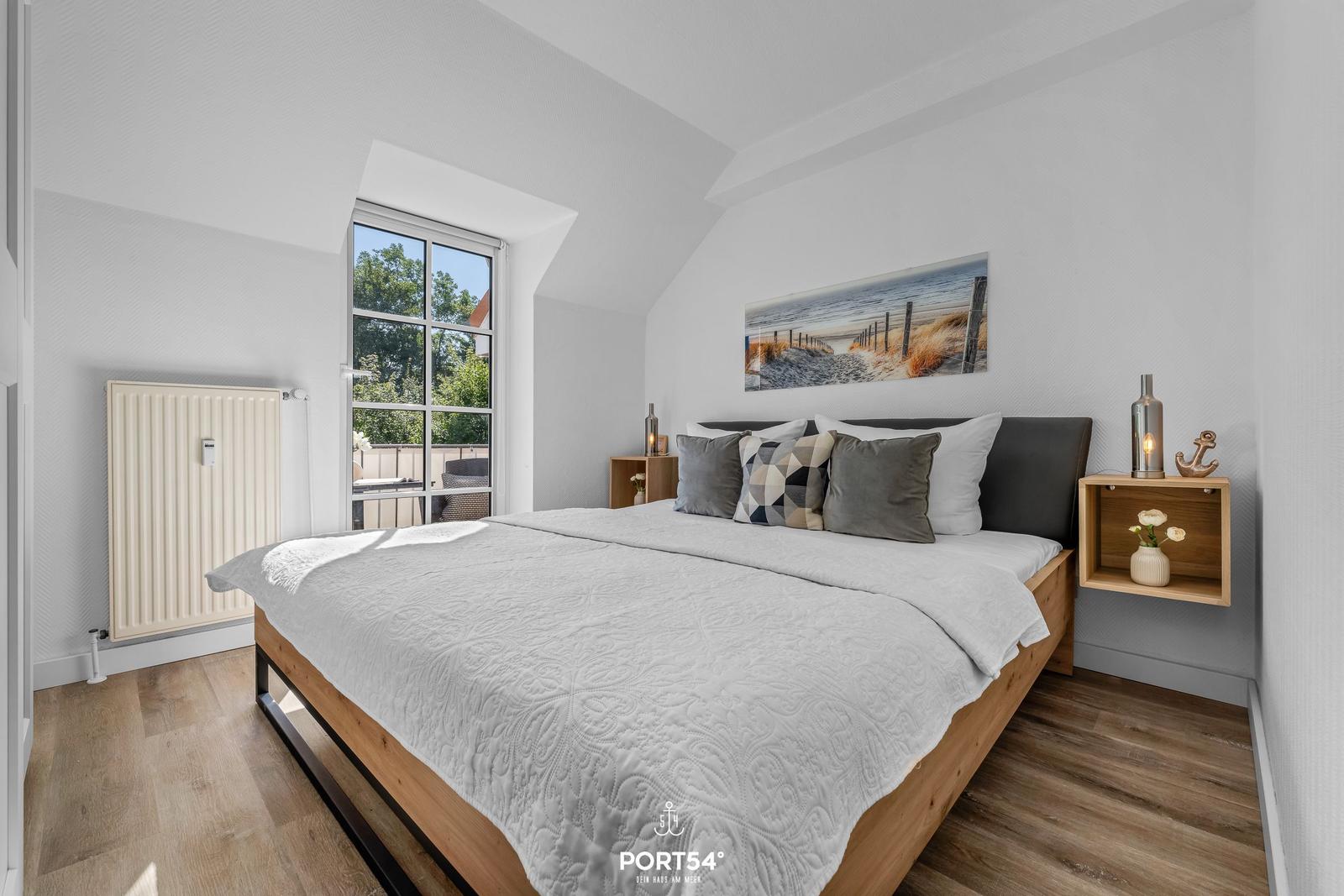 Schlafzimmer mit Bett, Fenster und Wandbild