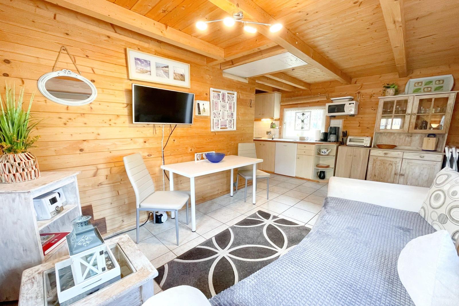 Wohnbereich mit Küche, Esstisch und Sofa in Holzhaus