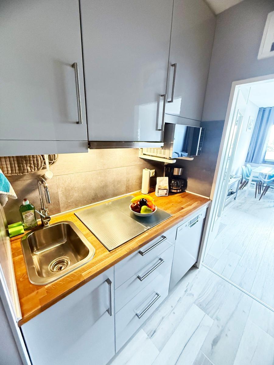 Küche mit Spüle, Arbeitsfläche und Mikrowelle.