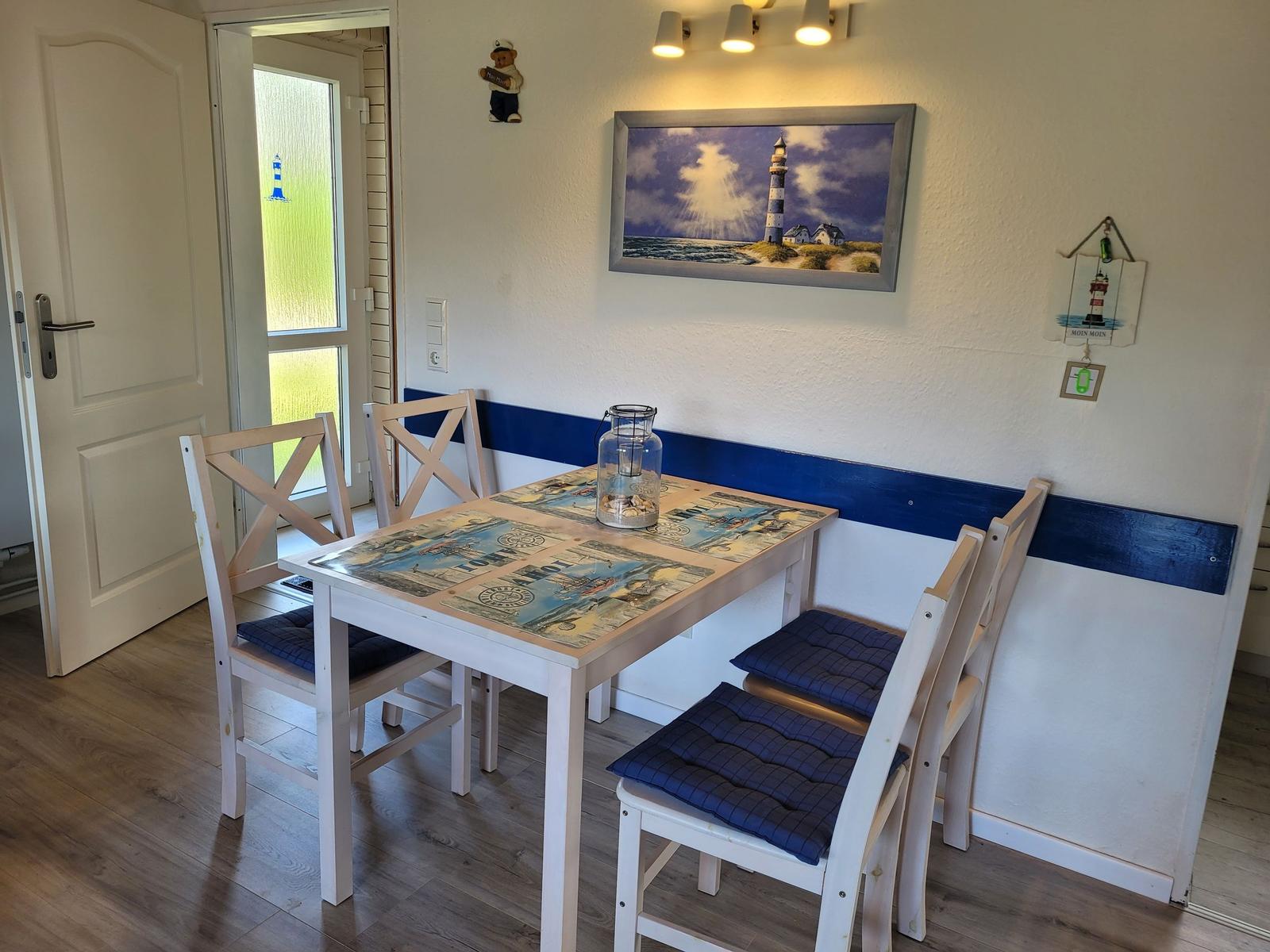 Essbereich mit Tisch, Stühlen und Leuchte an der Wand