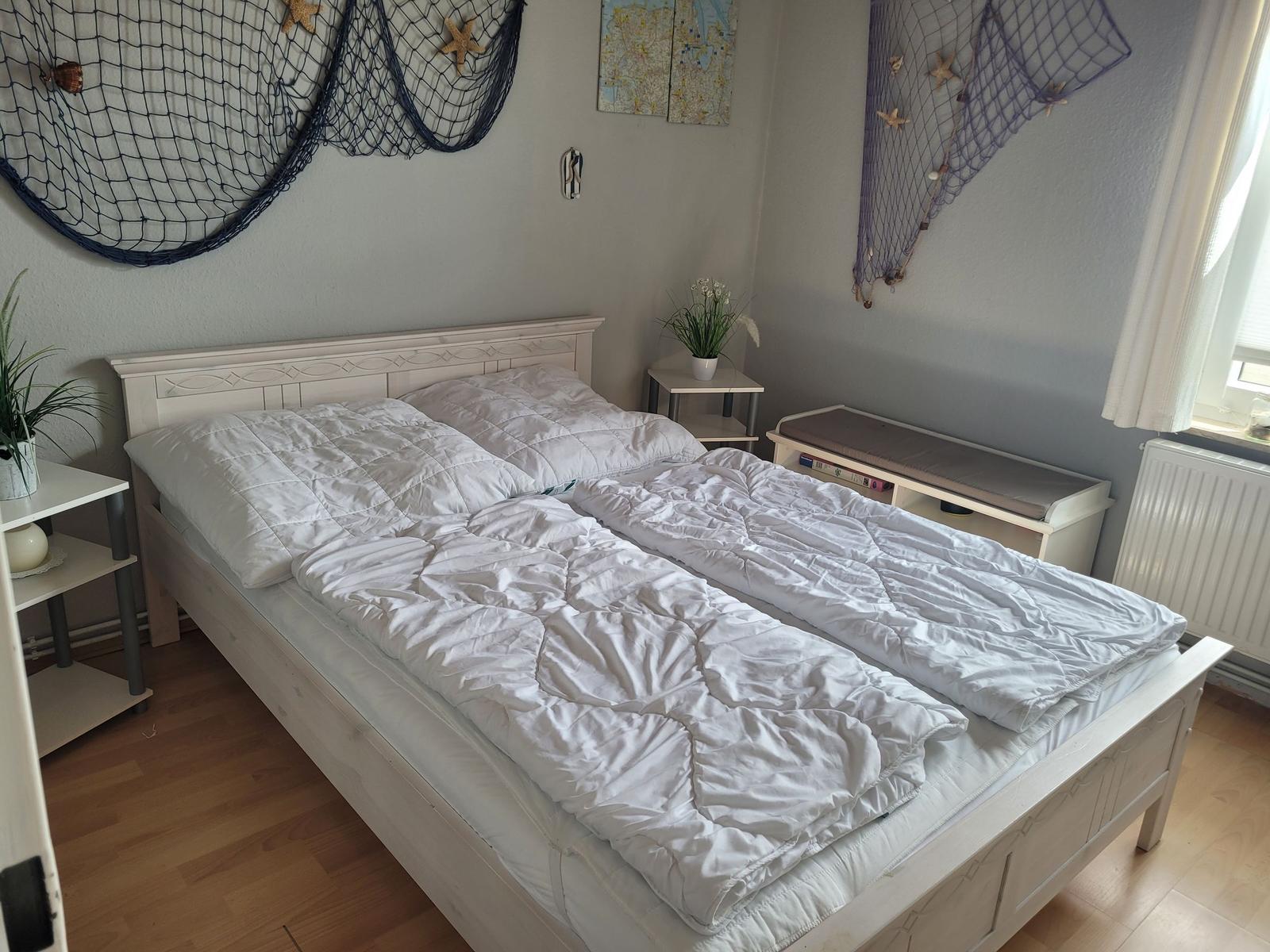 Schlafzimmer mit Bett, Nachttisch und Fenster