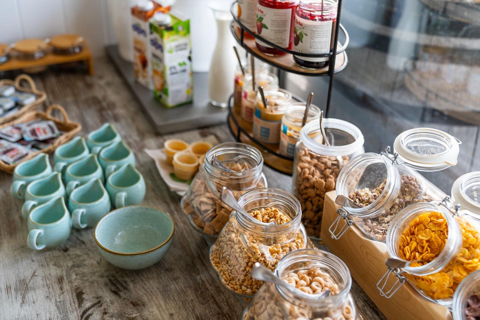 Frühstückstisch mit Getränken, Müsli und Porridge in Gläsern