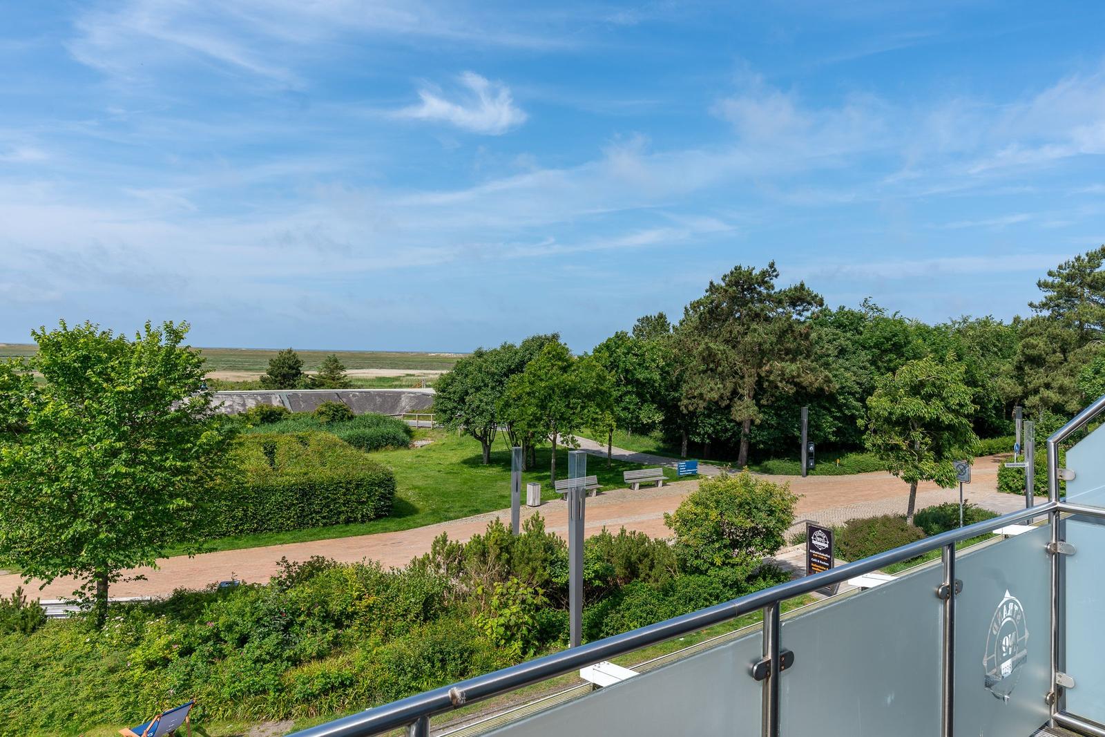 Terrasse mit Blick auf grünen Park und Strand