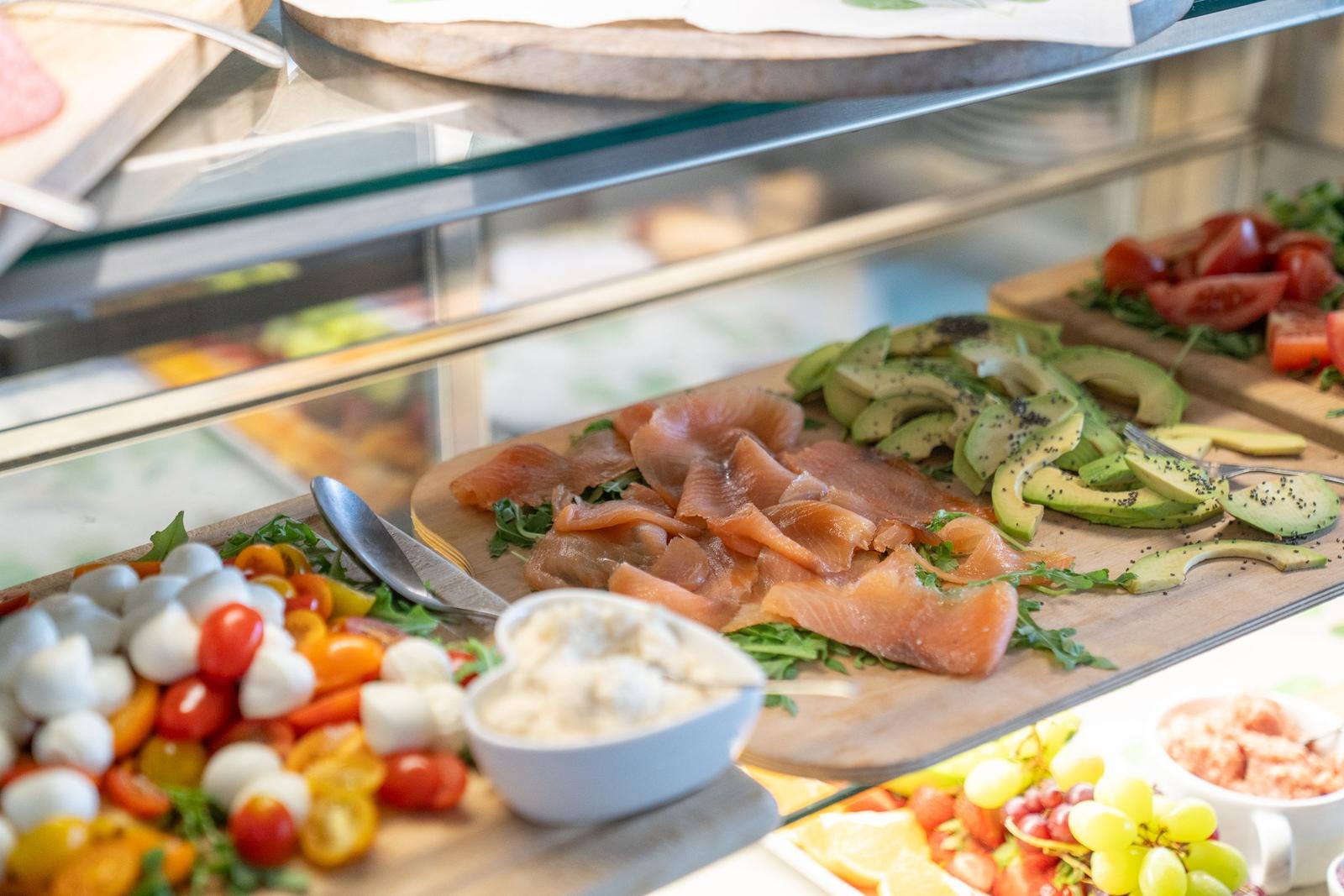 Frühstück mit Lachs, Avocado und Tomaten auf Holzbrettern.
