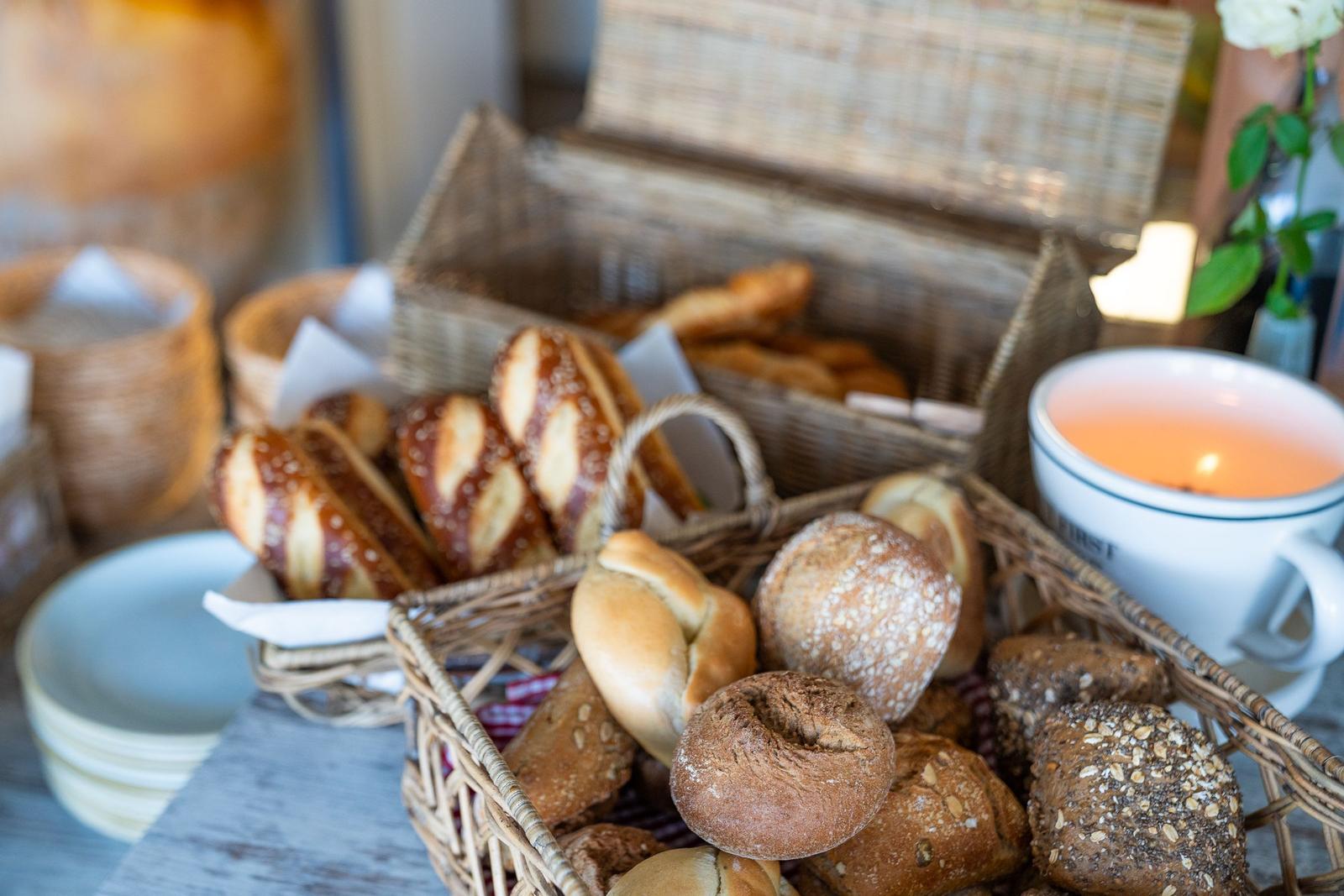 Frühstücksbrett mit Brotkörben und einer Tasse Tee.