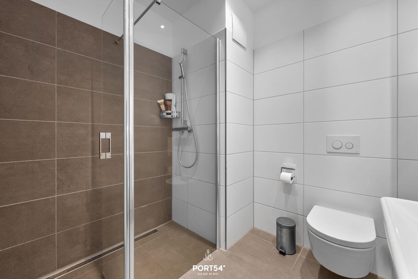 Bad mit Dusche, WC und Toilettenpapierhalter