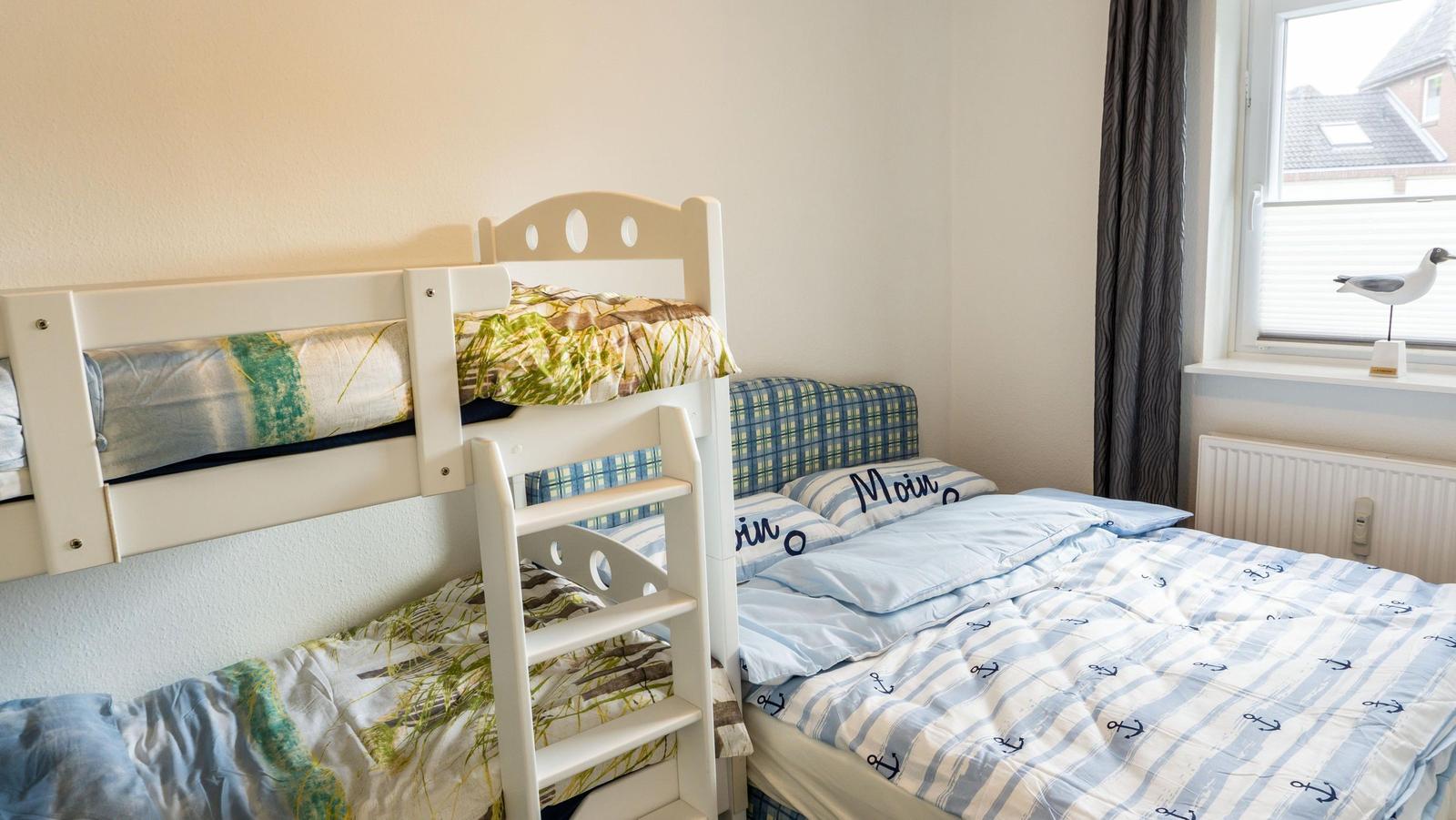 Zimmer mit Krippe und Einzelbett, Fenster mit Vogelskulptur.