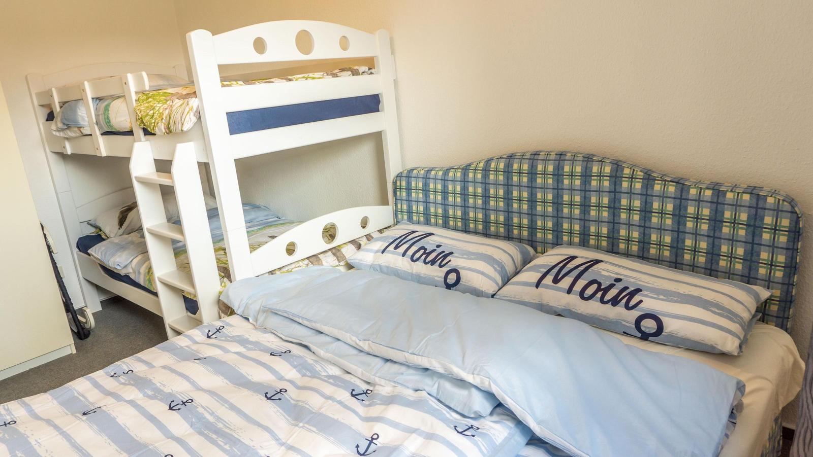 Zimmer mit Doppelbett und Kinderstockbett mit Seemannsmotiven.