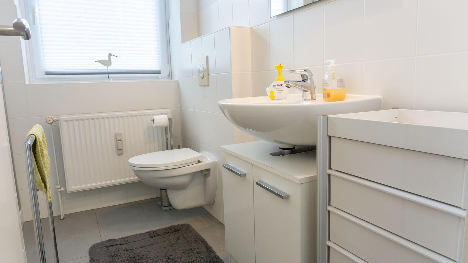 Badezimmer mit Toilette, Waschbecken und Heizkörper