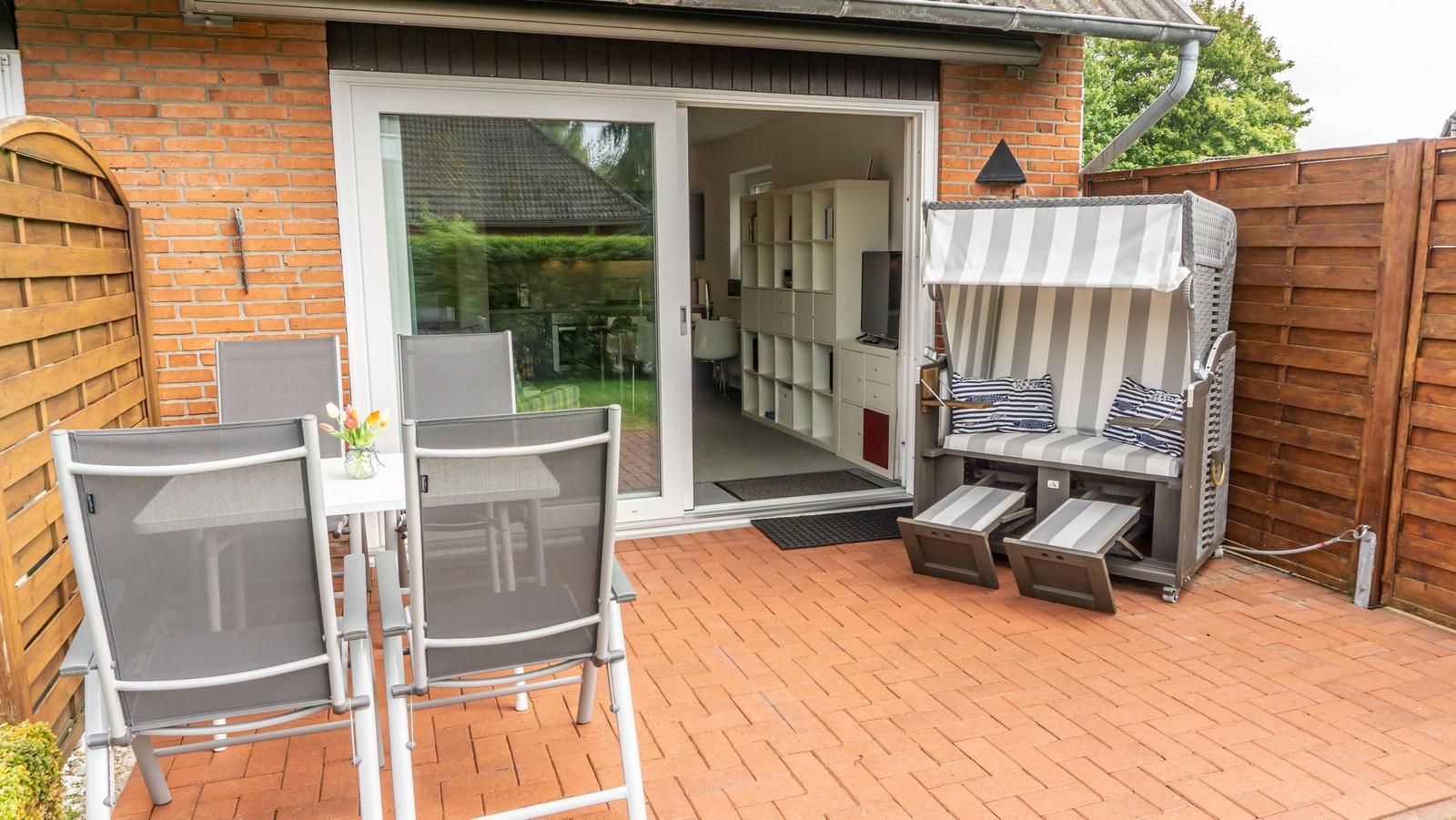 Terrasse mit Sitzgruppe, Strandkorb und Blick ins Haus.