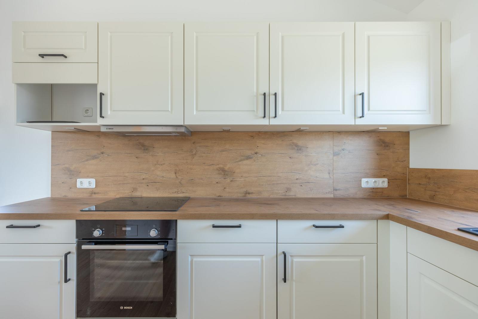 Küche mit weißen Schränken und Holzoberfläche.