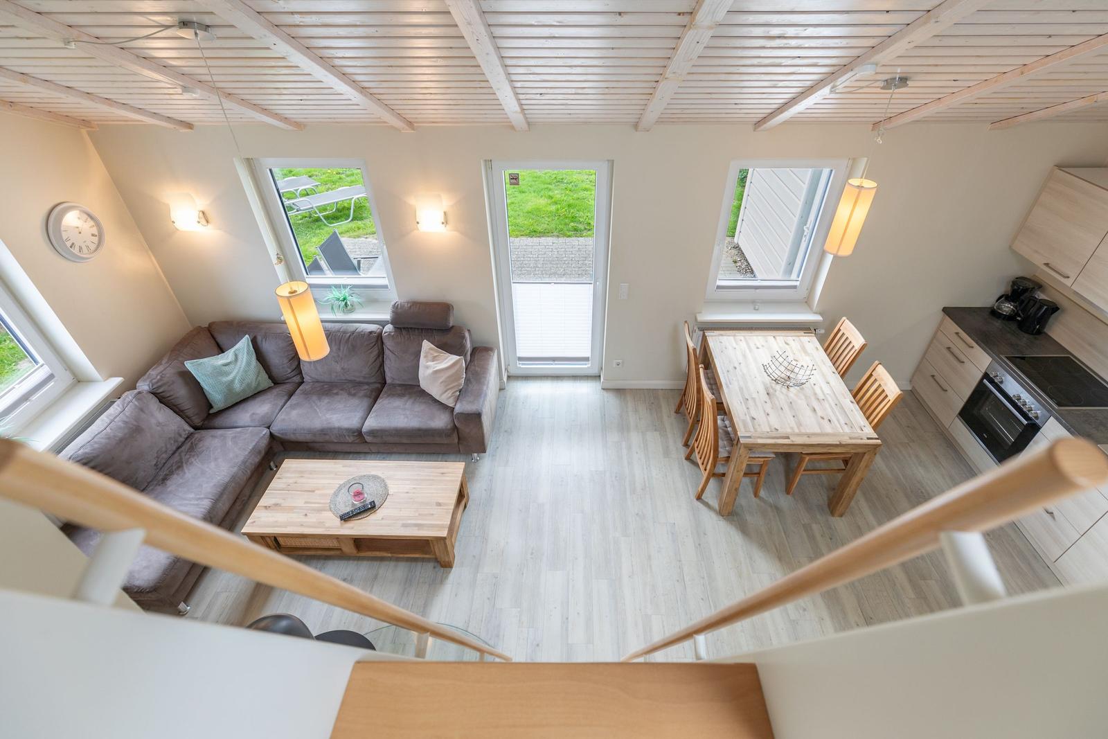 Wohn- und Essbereich mit Sofa, Tisch und Küchenzeile.