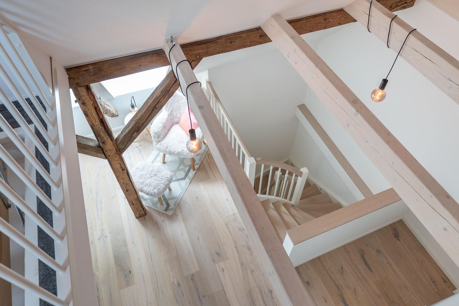 Haus mit Holzstufen und Balken, Sitzgelegenheit und Hängelampen