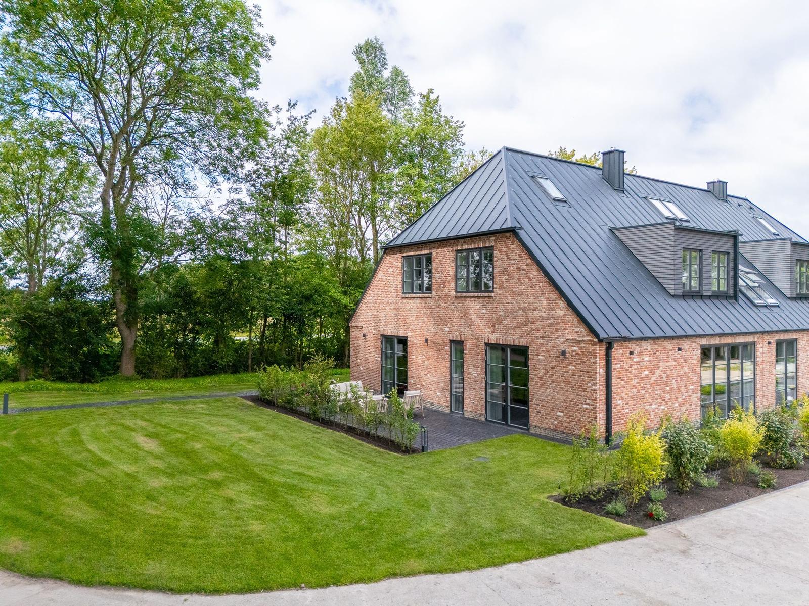 Moderne Backsteinhaus mit großem Garten und Terrasse.